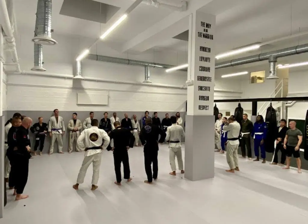 Photo de la cérémonie de passage de ceinture au Jiu-Jitsu Brésilien (jjb) où un groupe de combattant pratiquant cet art martial est en cercle dans sur le Tatami du Cube Fight Club